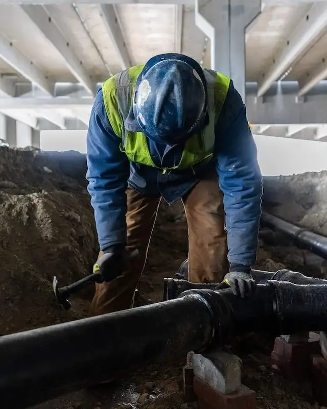 worker installing plumbing lines commercial 2